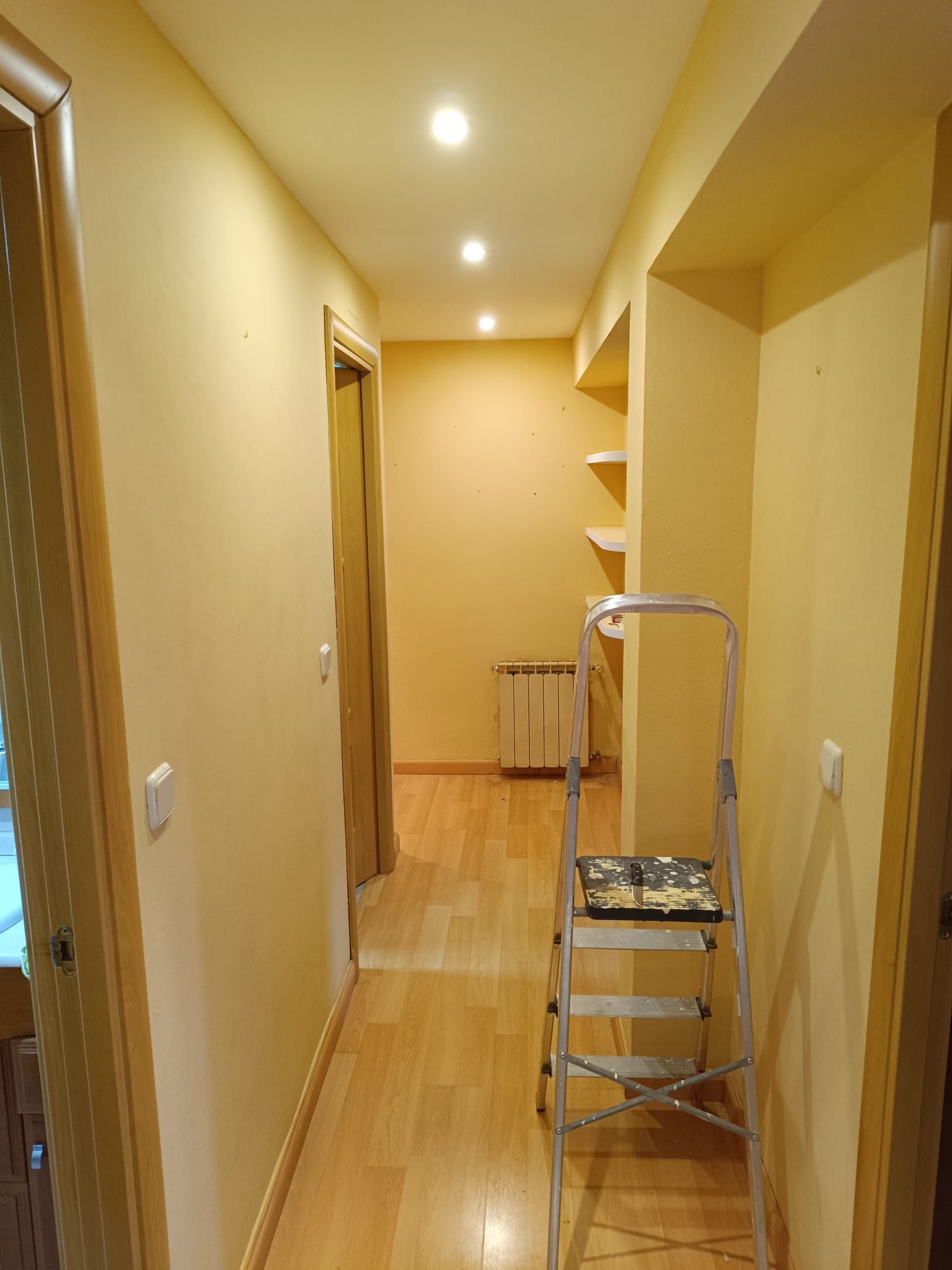 Un pasillo con una escalera en el medio.