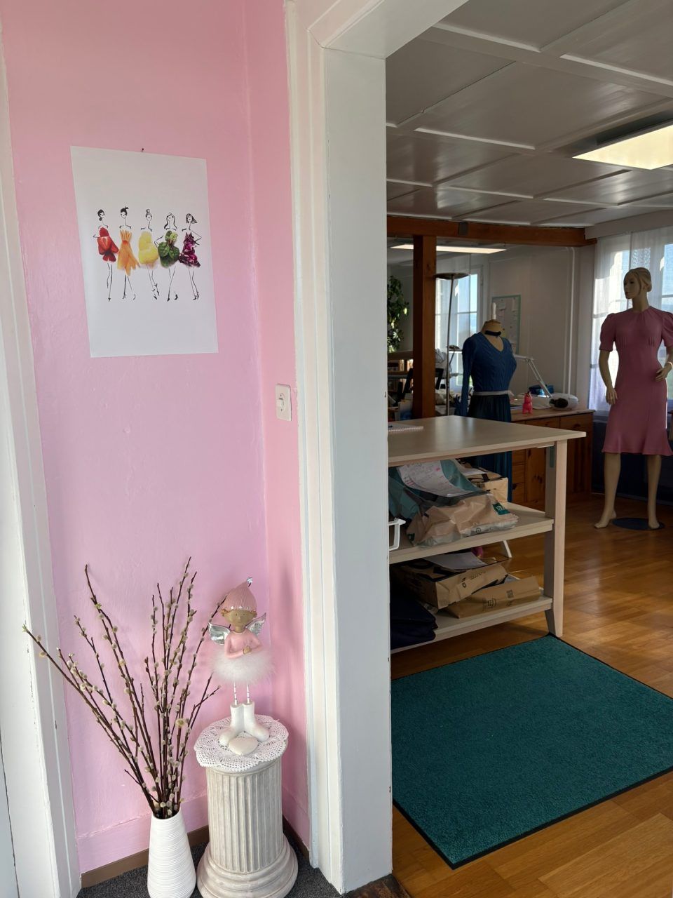 Eine Frau in einem rosa Kleid steht in einem Raum mit einer rosa Wand