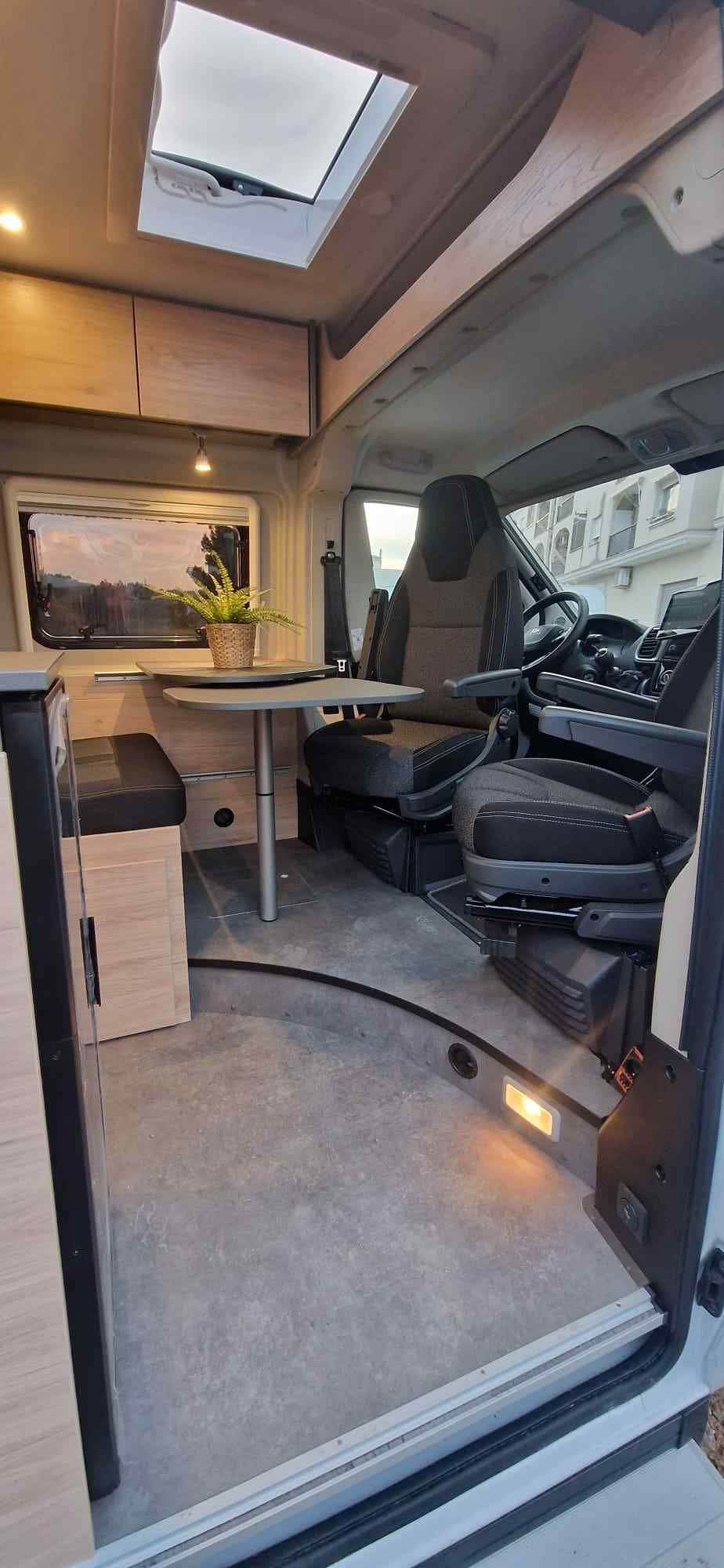 Persona con traje de protección rociando un sistema de pesticida montado en un vehículo sobre arbustos