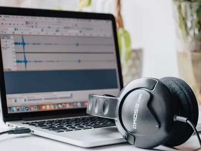 Un par de auriculares encima de una computadora portátil.