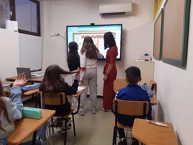 Un grupo de niños están en un aula con un profesor.