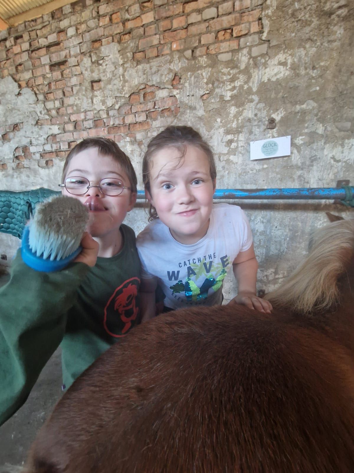 Ein Junge und ein Mädchen stehen neben einem Pferd.