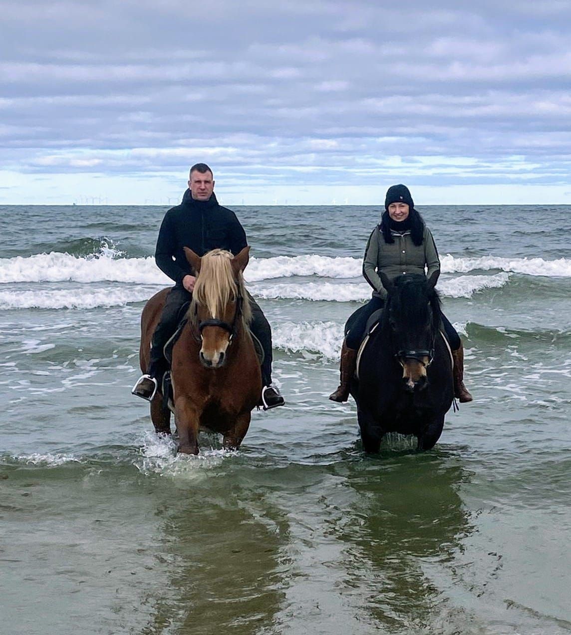 Ein Mann und eine Frau reiten im Meer.