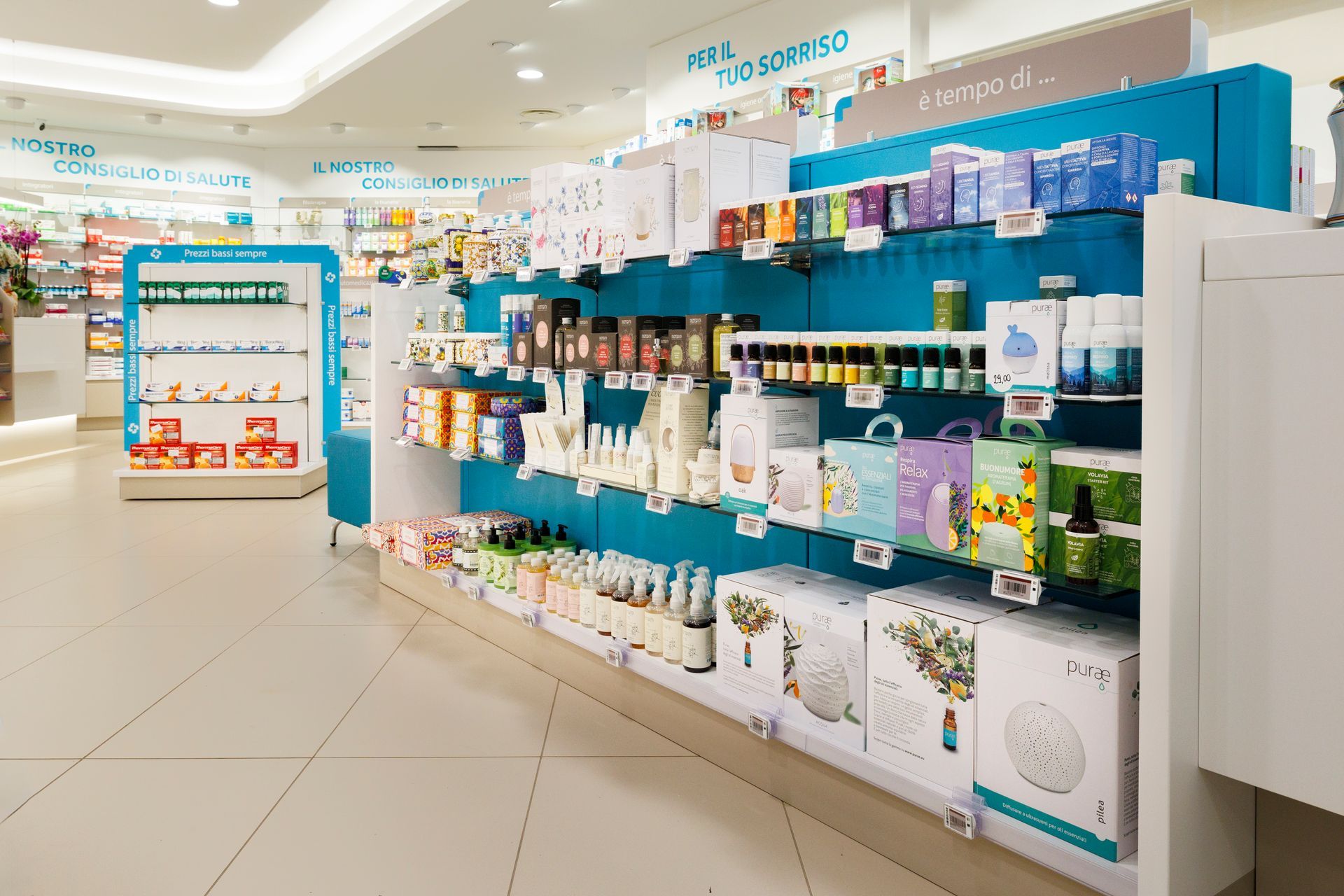 Luminoso corridoio della farmacia con scaffali blu pieni di medicinali e prodotti per la salute