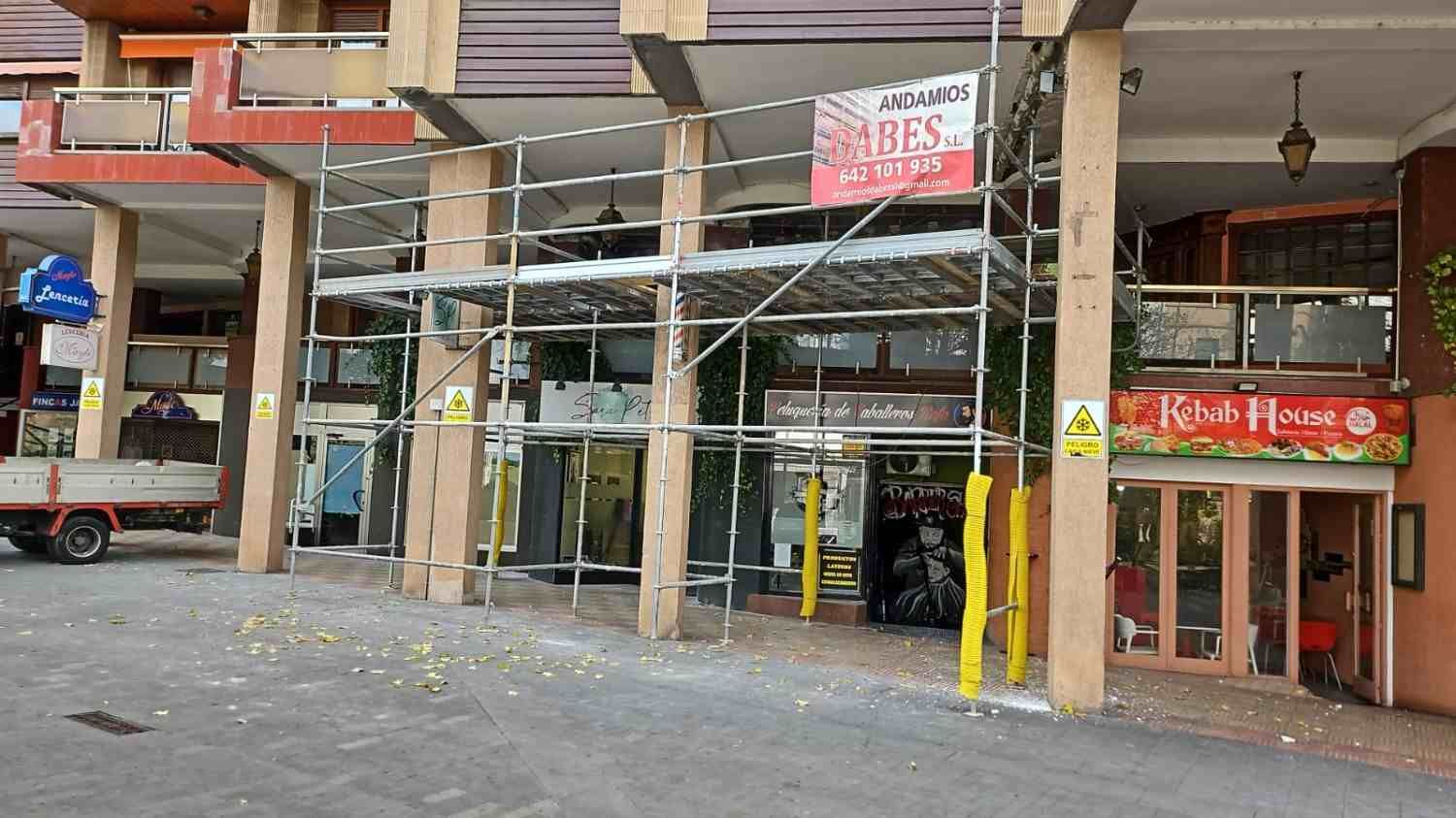 Edificio de piedra en obras, cubierto por un andamio