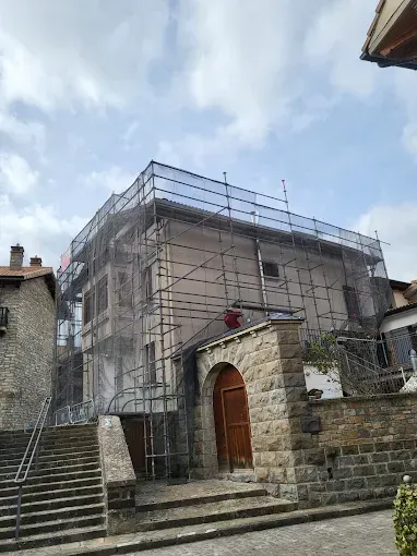 Edificio de piedra en obras, cubierto por un andamio