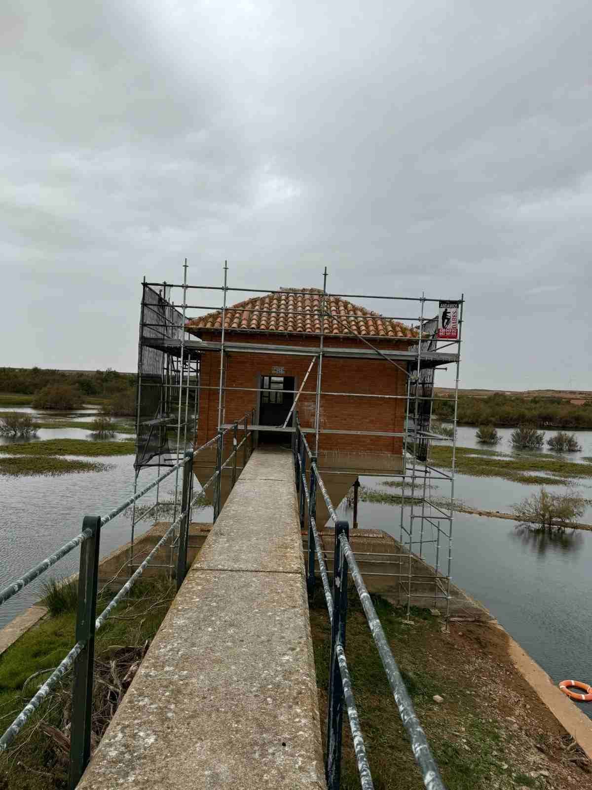 Pequeño edificio de ladrillo sobre un andamio al final