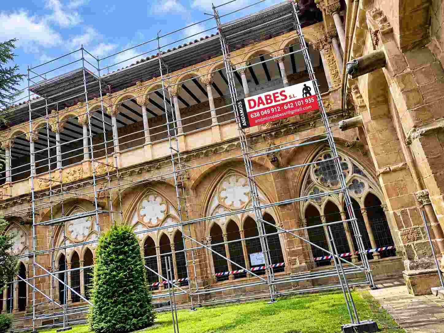 Fachada de un edificio histórico en renovación, con andamios y ventanas arqueadas