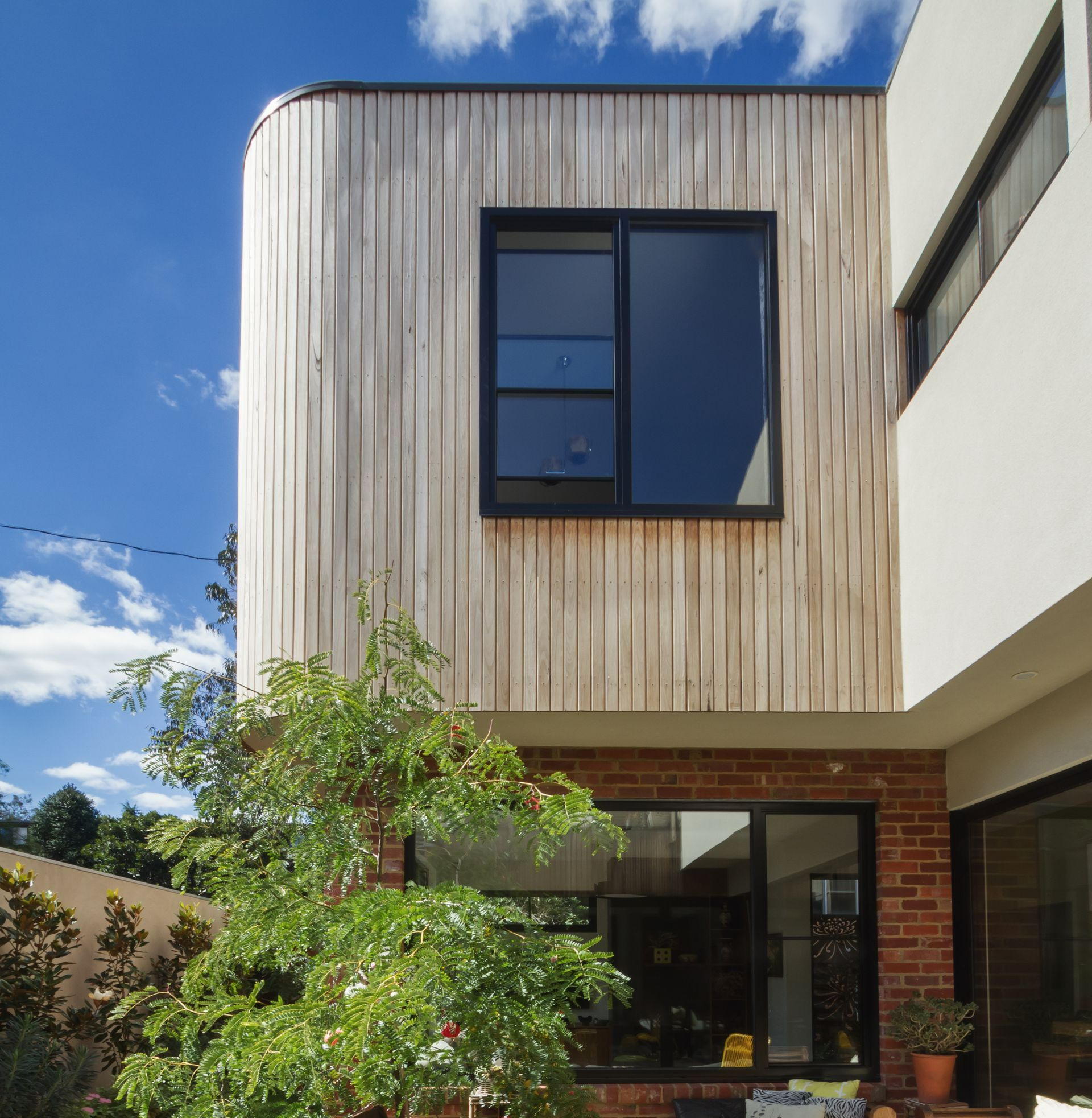 Une surélévation de maison en bois avec une fenêtre en aluminium
