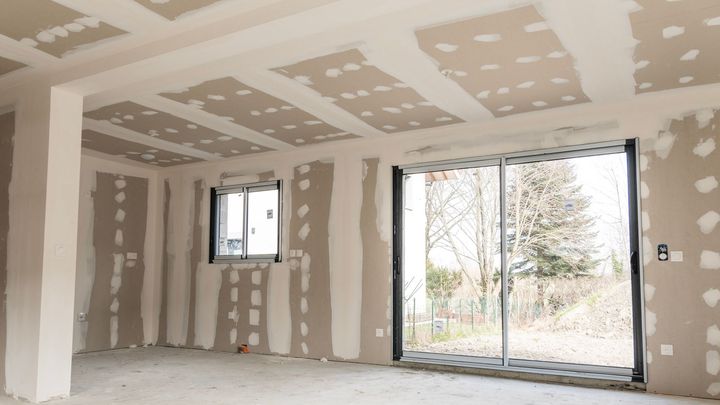 Un salon avec des murs et plafonds enduits