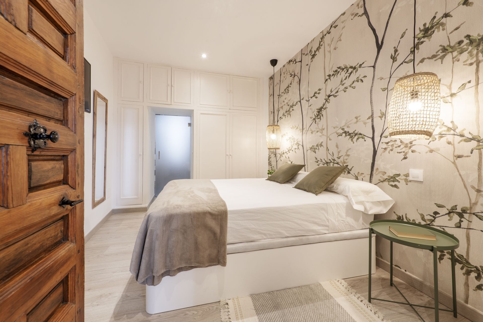 Une chambre avec un papier peint floral et des touches de vert