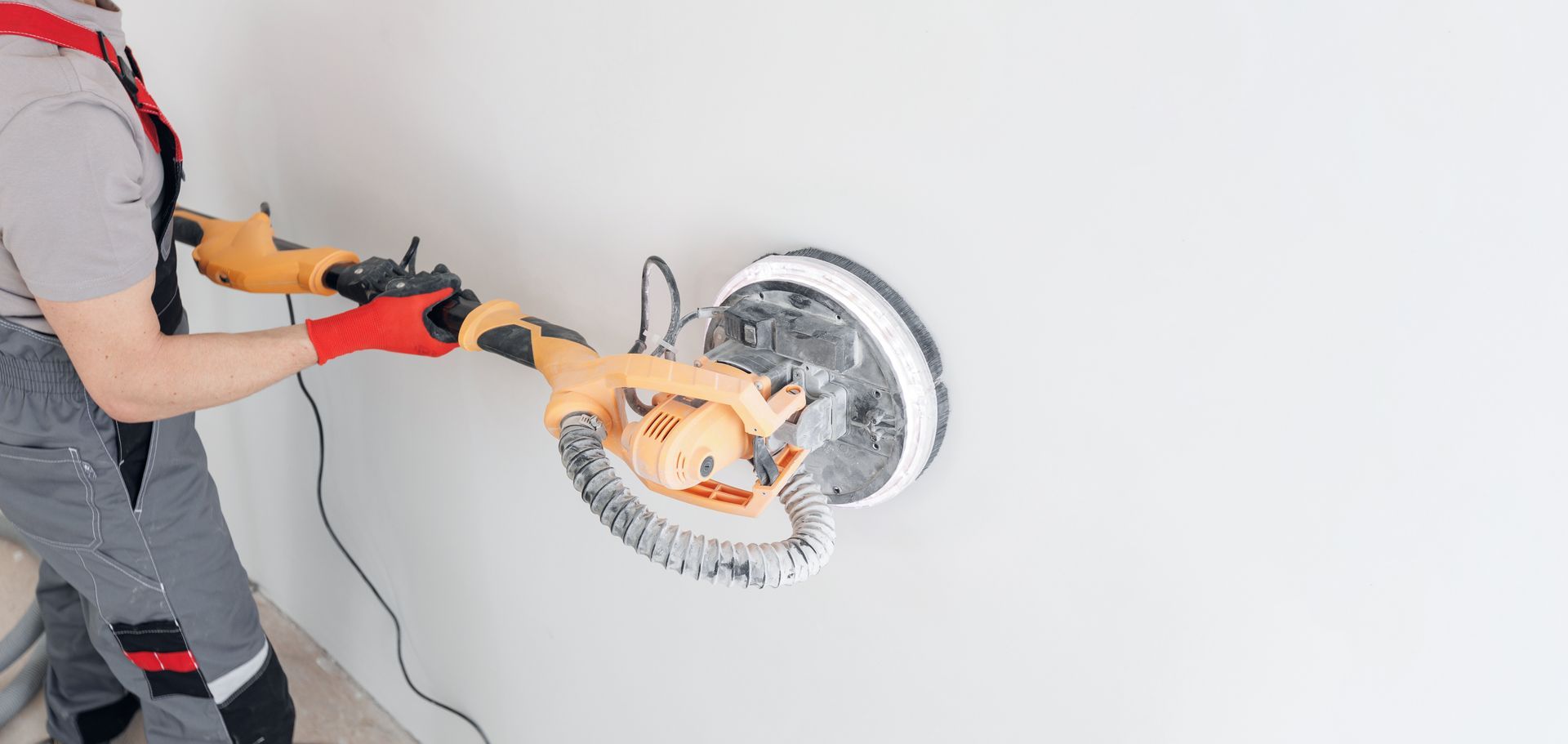 Zoom sur une ponceuse sur un mur