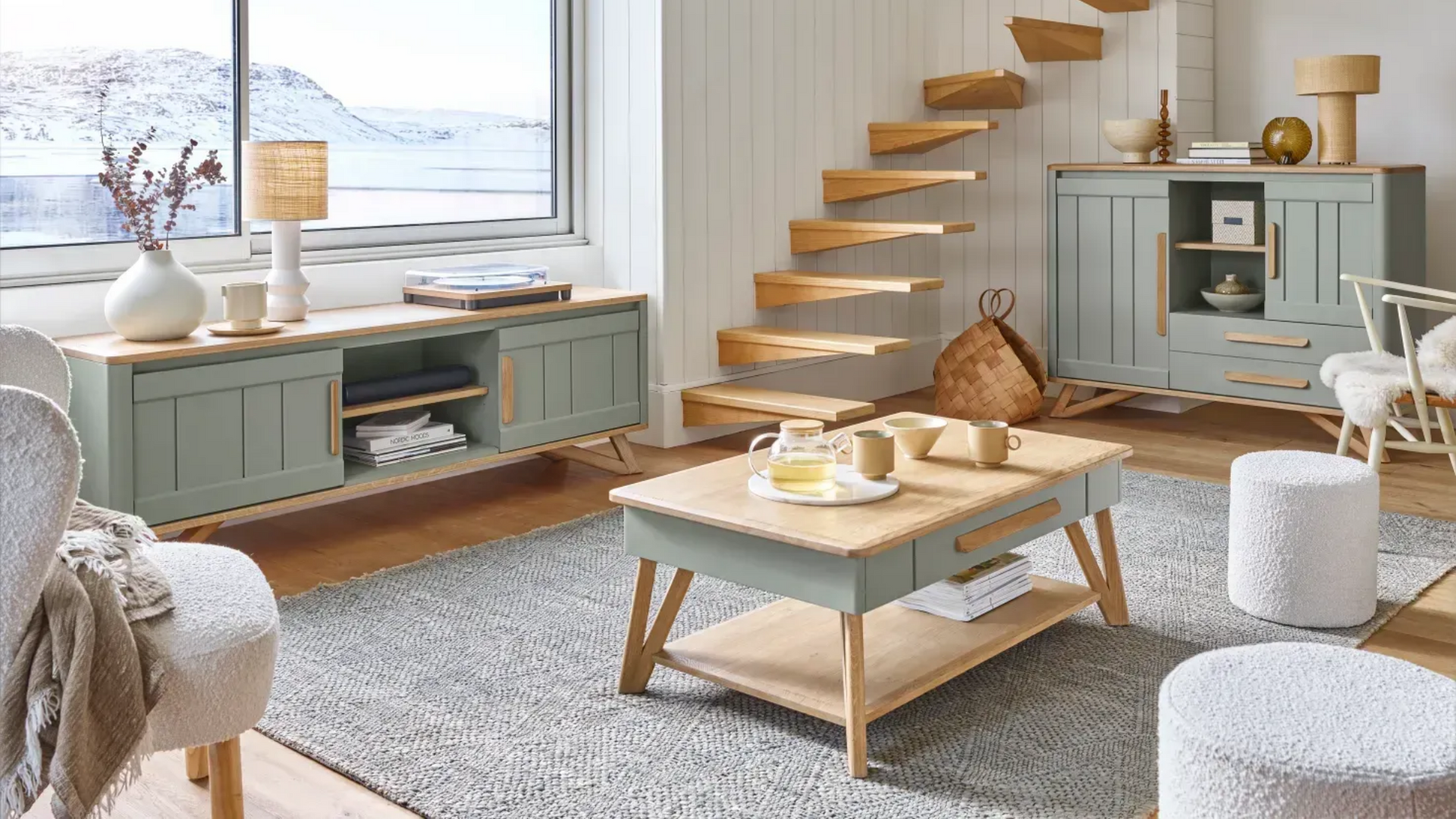 Salon avec placards verts, escalier en bois et vue sur la neige par la fenêtre.
