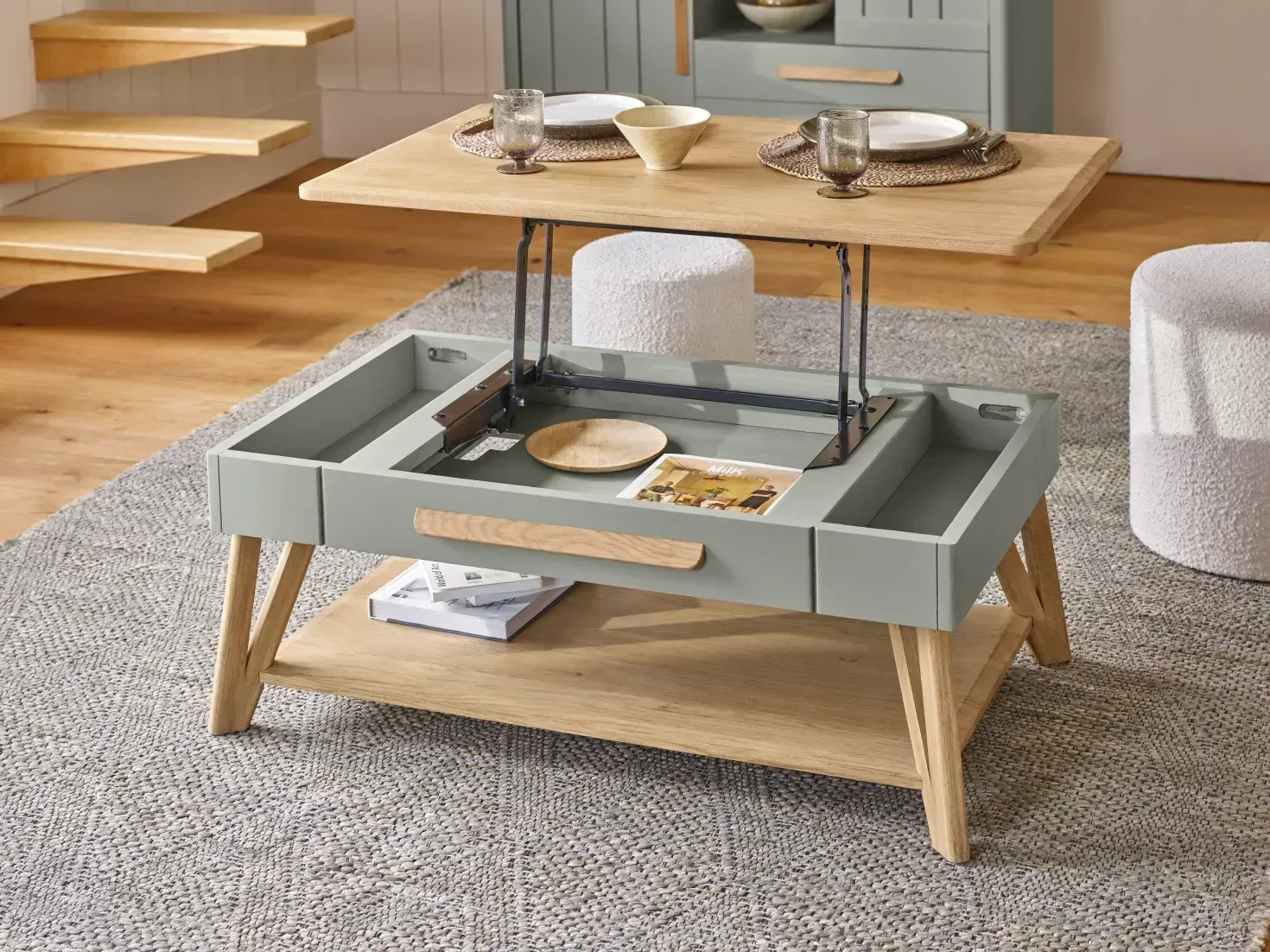 Table basse relevable dans un salon, en bois clair et gris, avec un plateau surélevé révélant un espace de rangement.