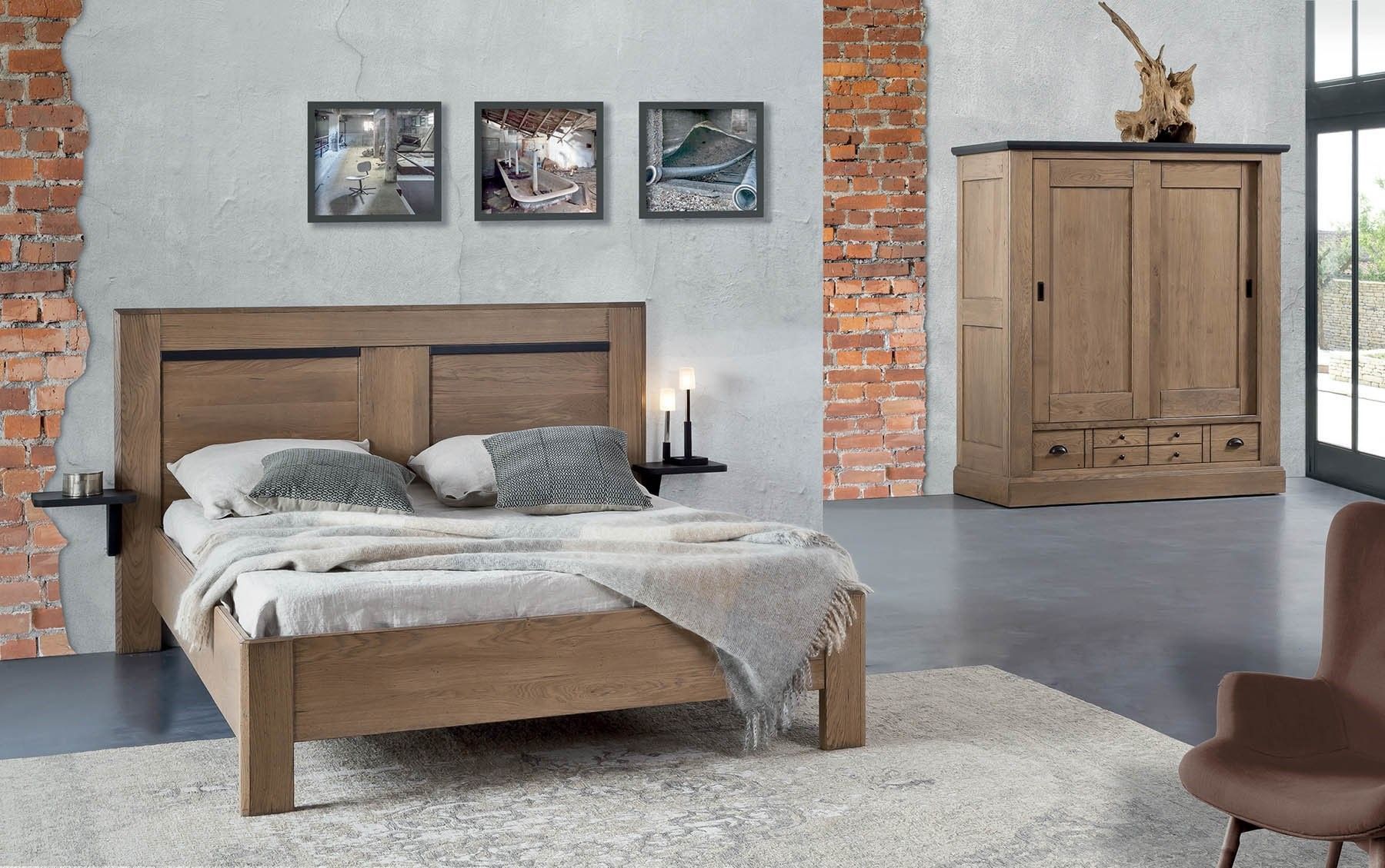 Chambre avec lit en bois, armoire et tableau encadré sur un mur texturé, avec une chaise et un tapis.