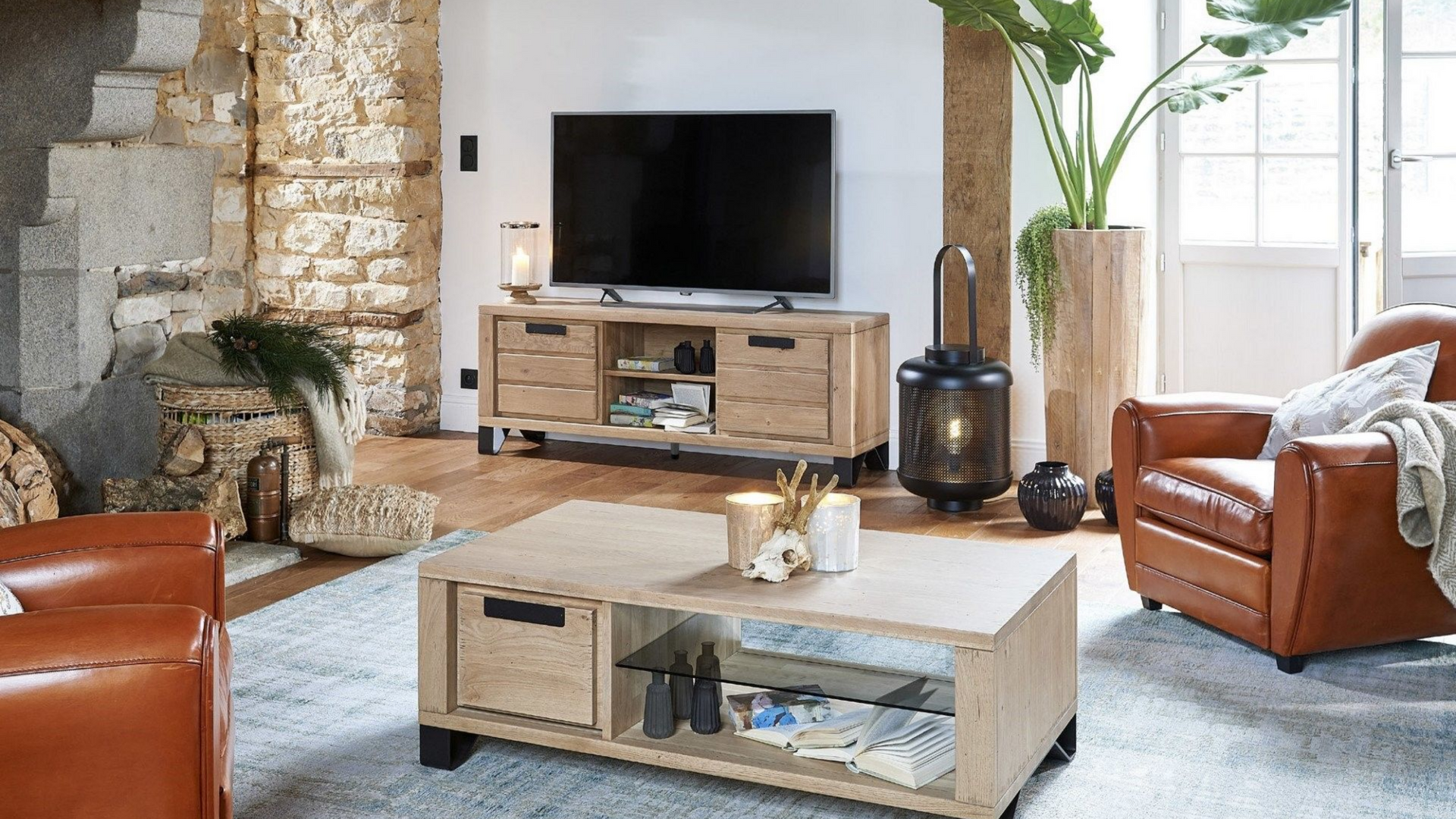 Salon avec meubles en bois, télévision, fauteuils en cuir et grande plante.