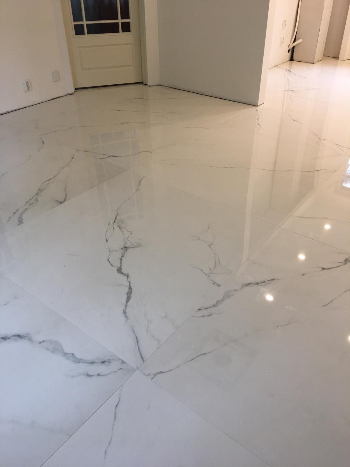 Suurikokoisen lattialaatan asennus ja kiiltävä marmoripinta huoneistoremontissa Pintapiste Oy