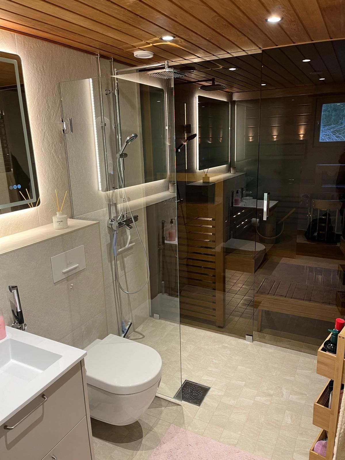 Kokonaisvaltainen märkätilasaneeraus, lasiseinä saunan ja kylpyhuoneen välillä.