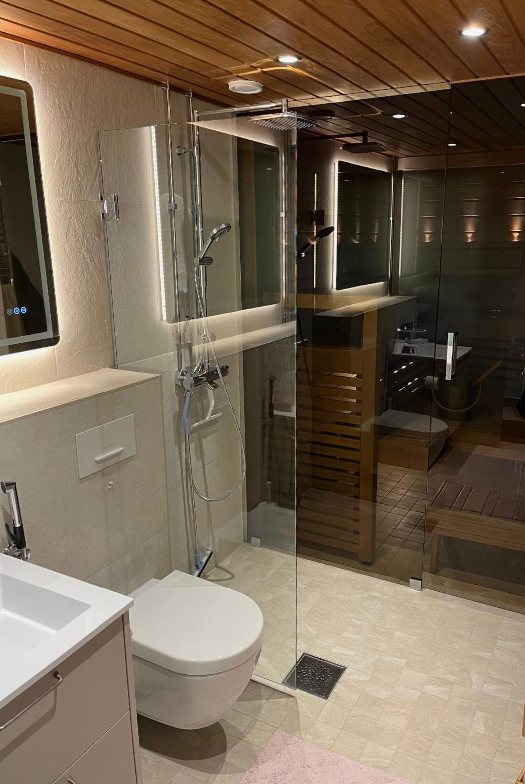 Kokonaisvaltainen märkätilasaneeraus, lasiseinä saunan ja kylpyhuoneen välillä.