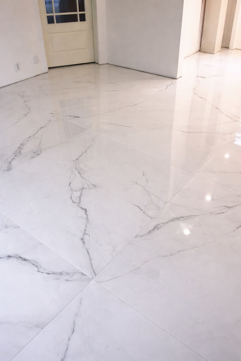 Suurikokoisen lattialaatan asennus ja kiiltävä marmoripinta huoneistoremontissa Pintapiste Oy