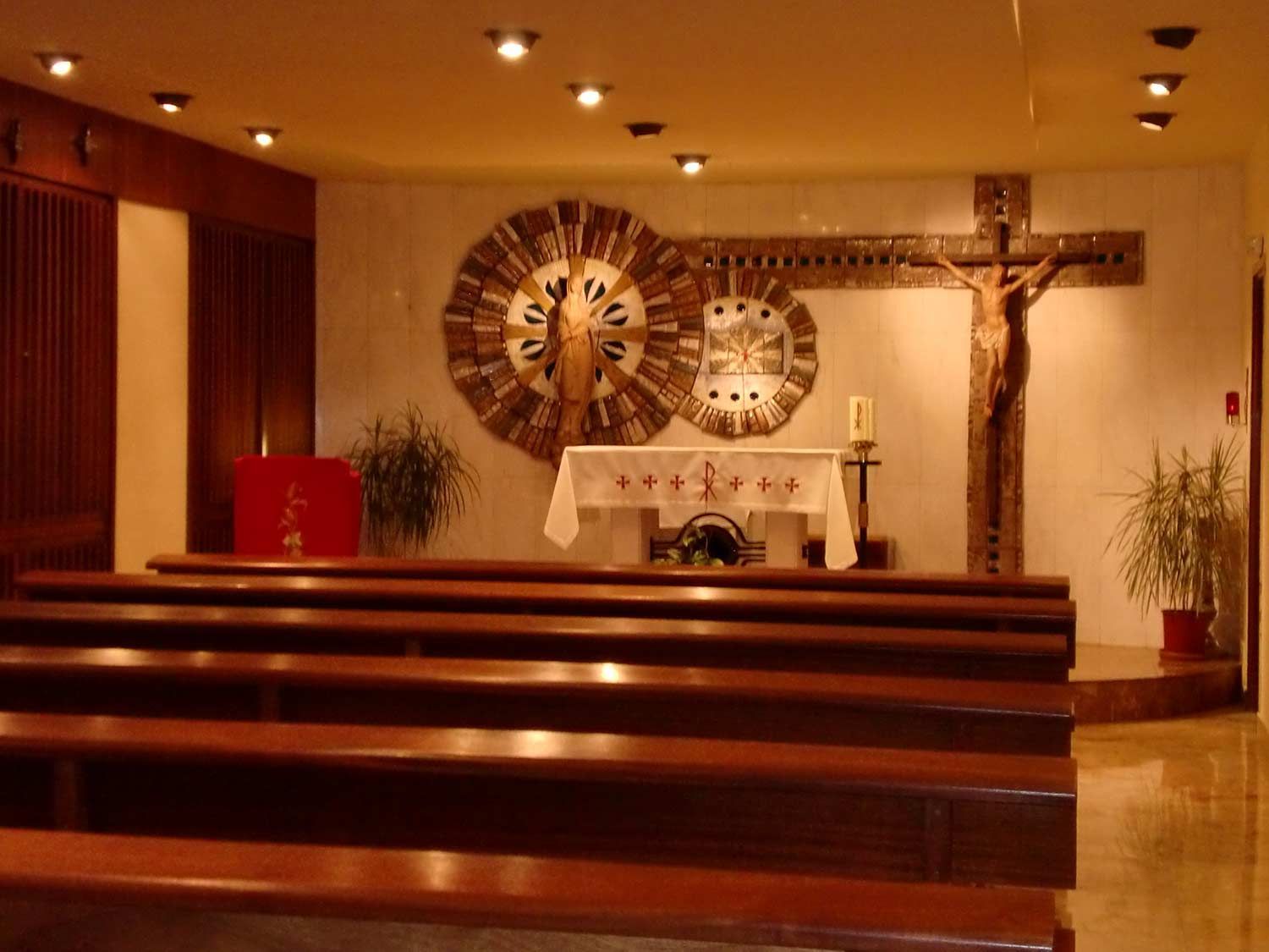 Una iglesia con una cruz y relojes en la pared.