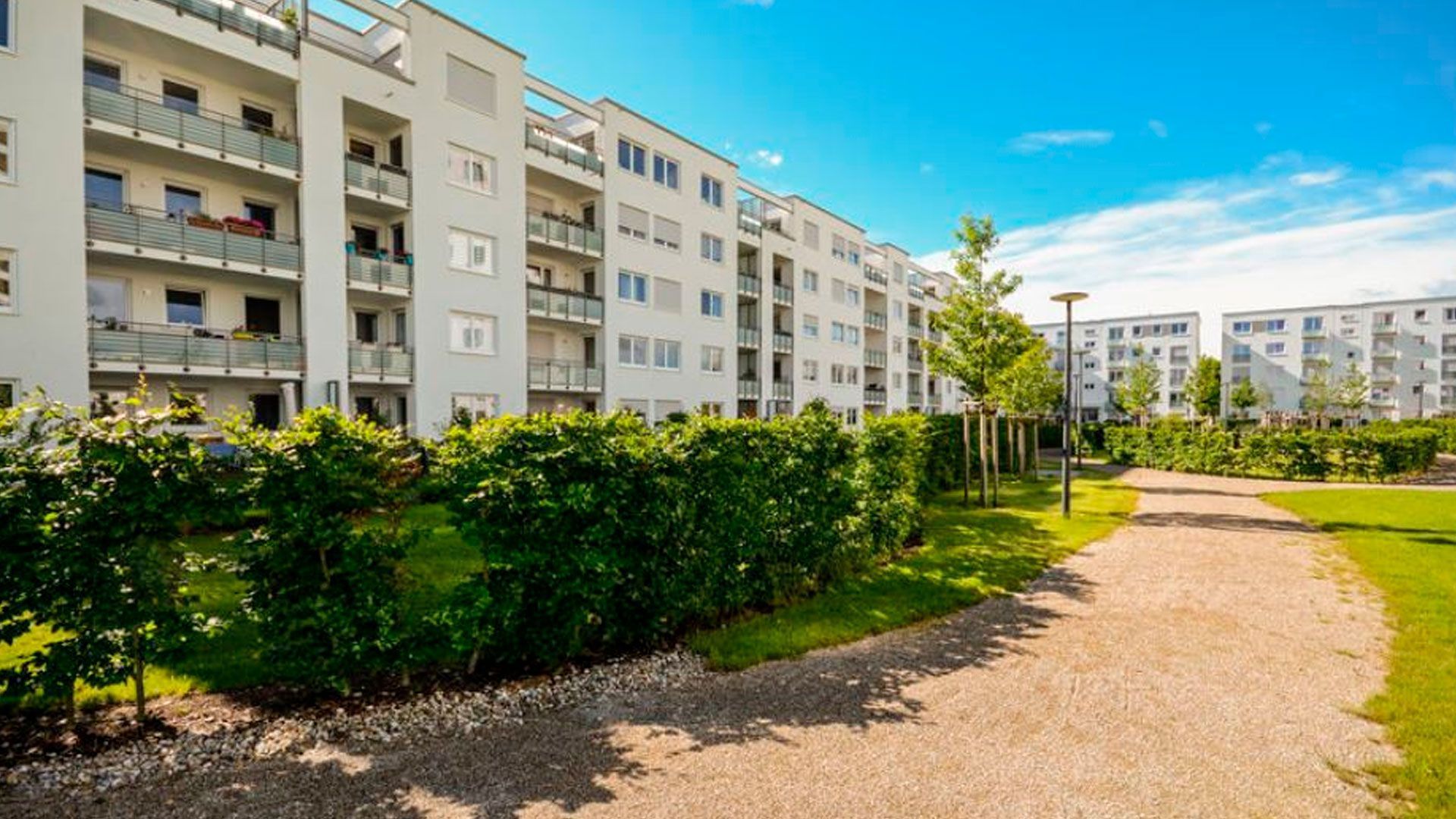 Una hilera de edificios de apartamentos con un camino que conduce a ellos.