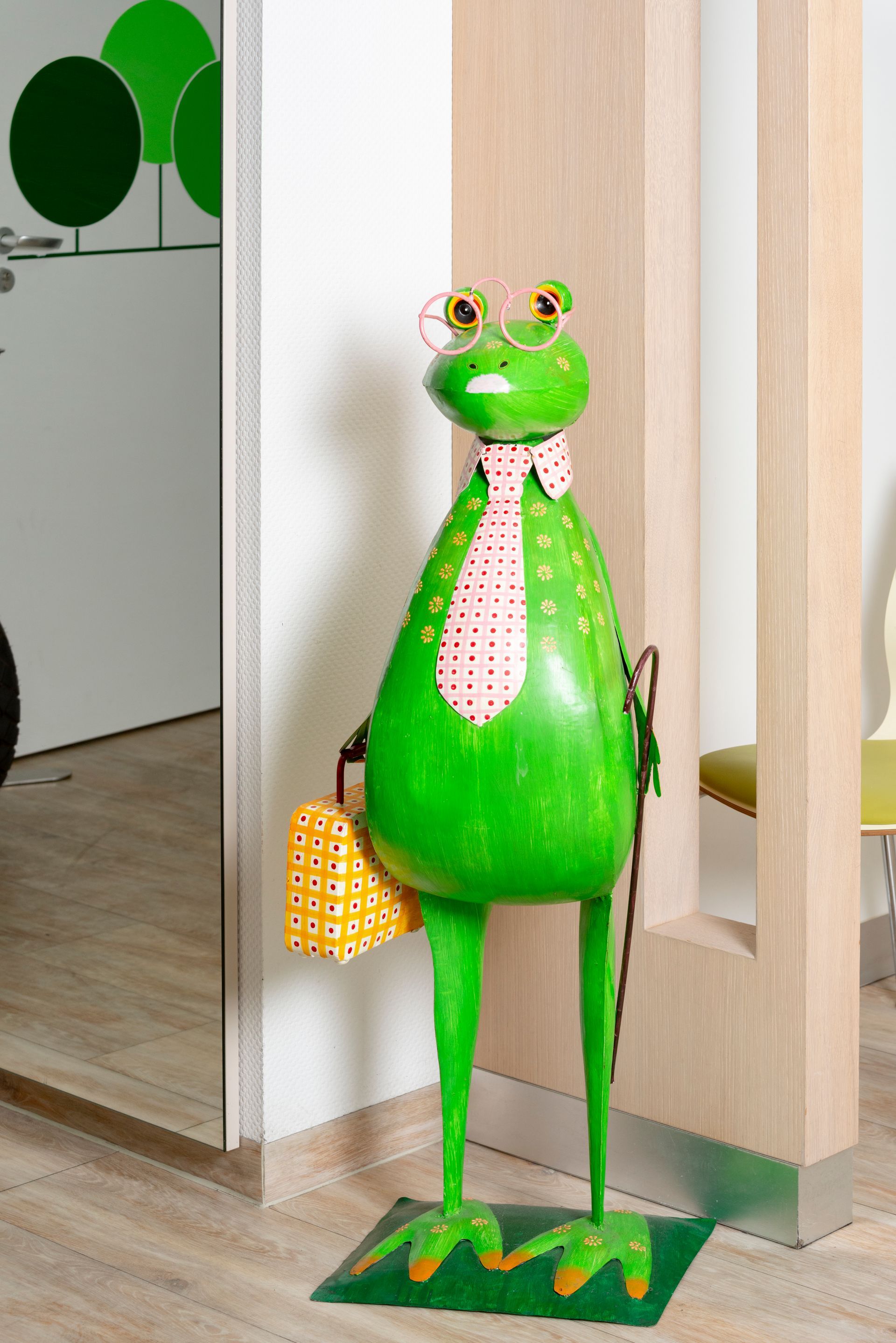 Grüner Holzfrosch steht als Deko im Wartezimmer