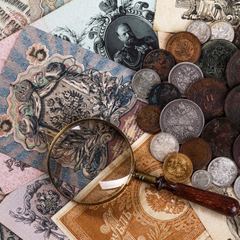 Una lupa está colocada encima de una pila de dinero y monedas.