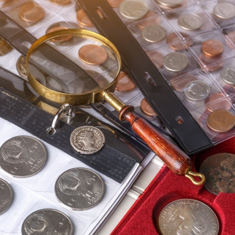 Una lupa se encuentra encima de una colección de monedas.