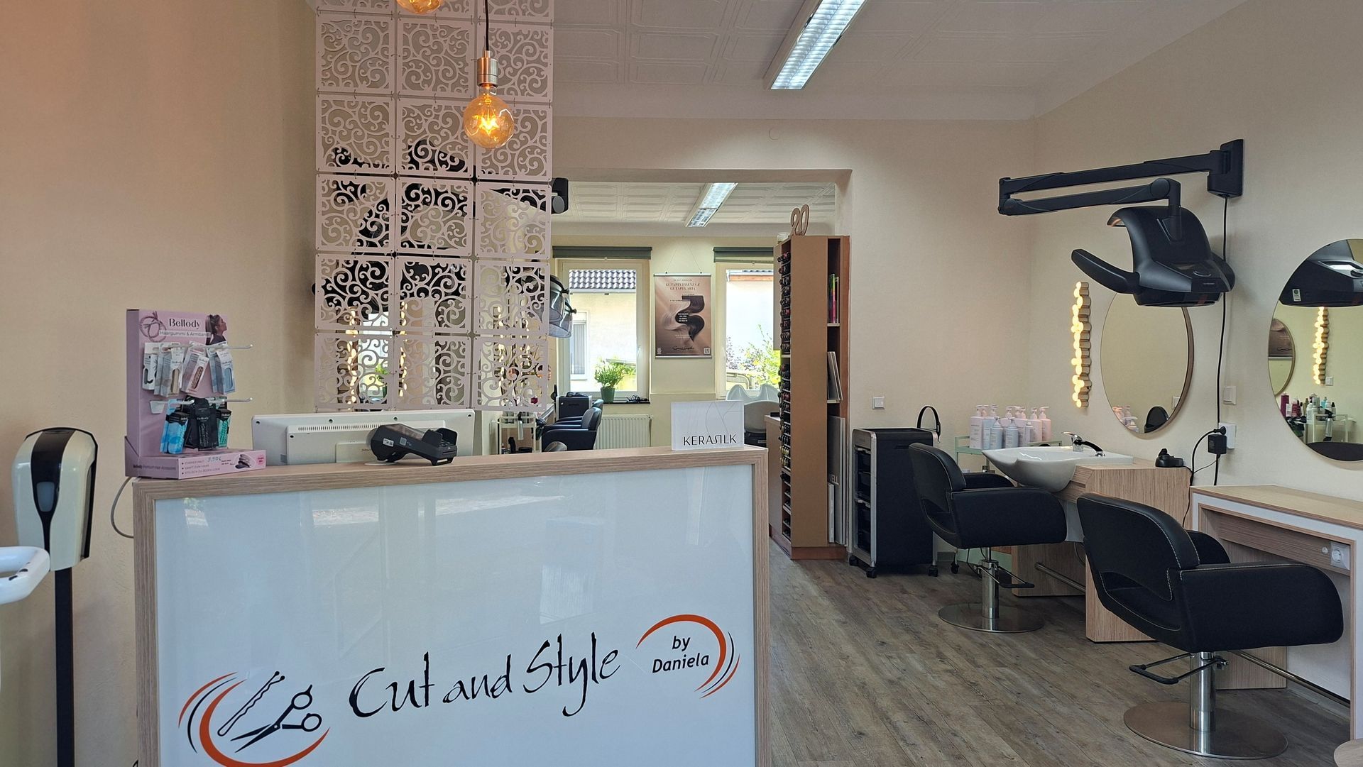 Modernes Saloninterieur mit weißer Rezeption, Friseurstühlen, Spiegeln und Hängeleuchten