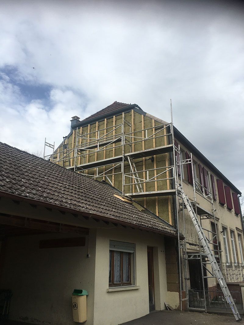 Chantier en cours sur une façade d'une maison pour l'isolation de la façade avant la pose d'un bardage