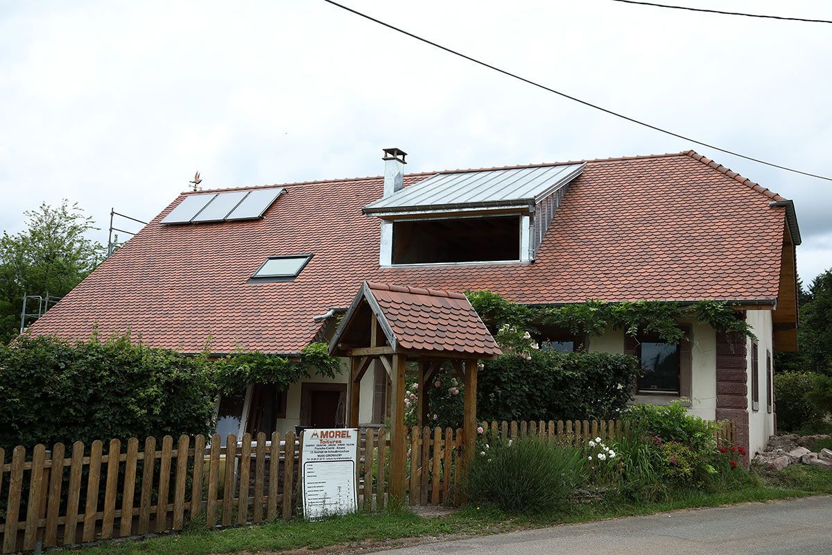 Maison avec des tuiles plates et des fenêtres de toit
