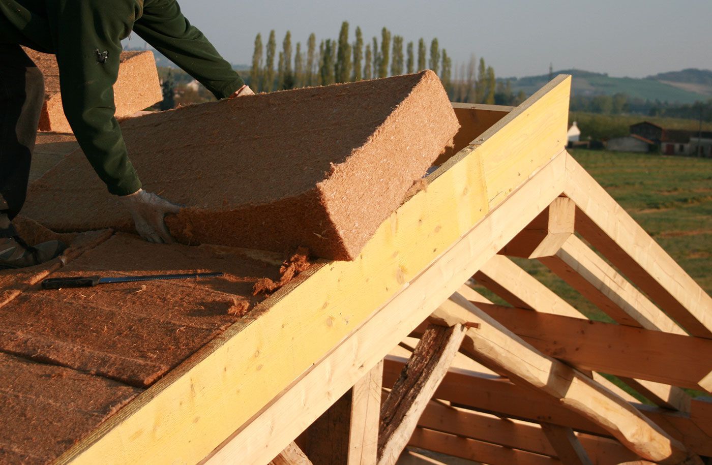 Gros plan sur un ouvrier qui pratique le sarking à la laine de bois