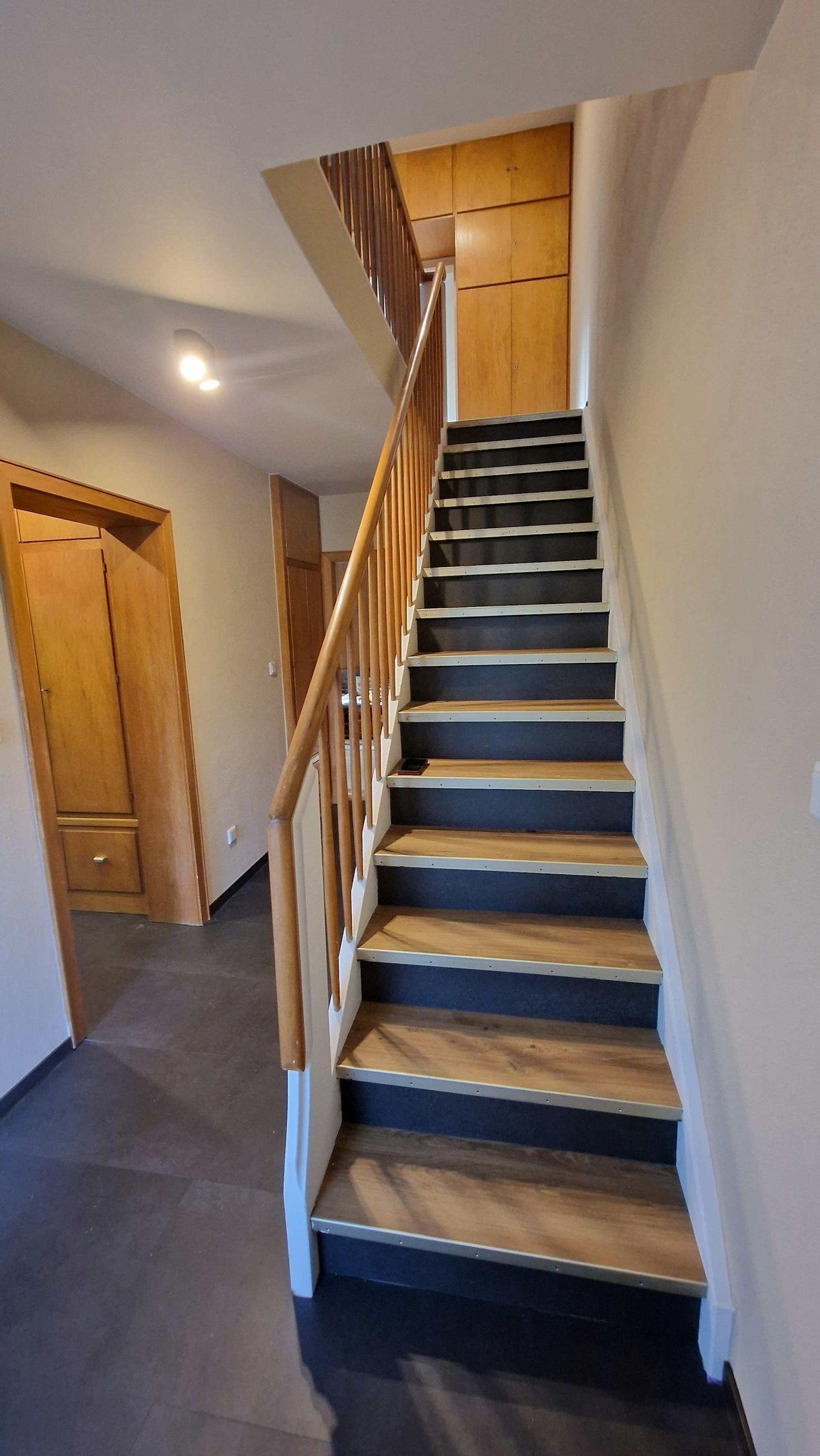 Treppe mit Trittstufen aus Eiche und Vorstöße aus dunkler Granitoptik. Verlegt mit Klebevinyl. - Referenzen der Malermeisterin Stefanie Würfel aus Bielefeld