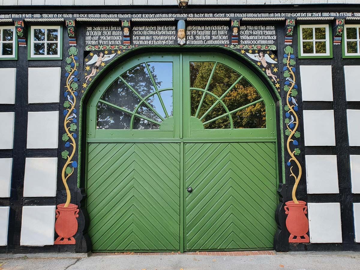 eine grüne Tür mit einem schwarz-weißen Gebäude dahinter - Malermeisterin Stefanie Würfel aus Bielefeld