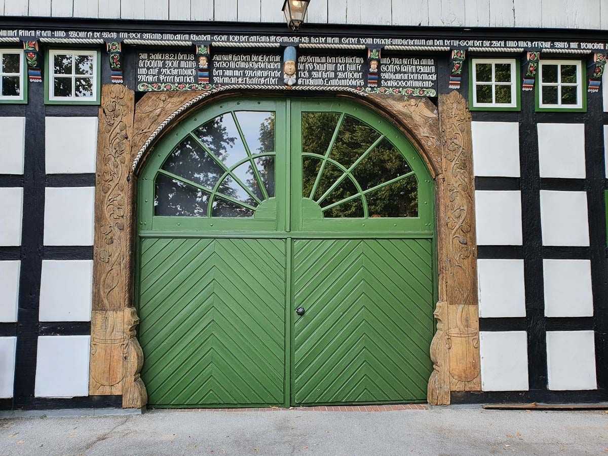 eine grüne Tür auf einem schwarz-weißen Gebäude - Referenzen der Malermeisterin Stefanie Würfel aus Bielefeld