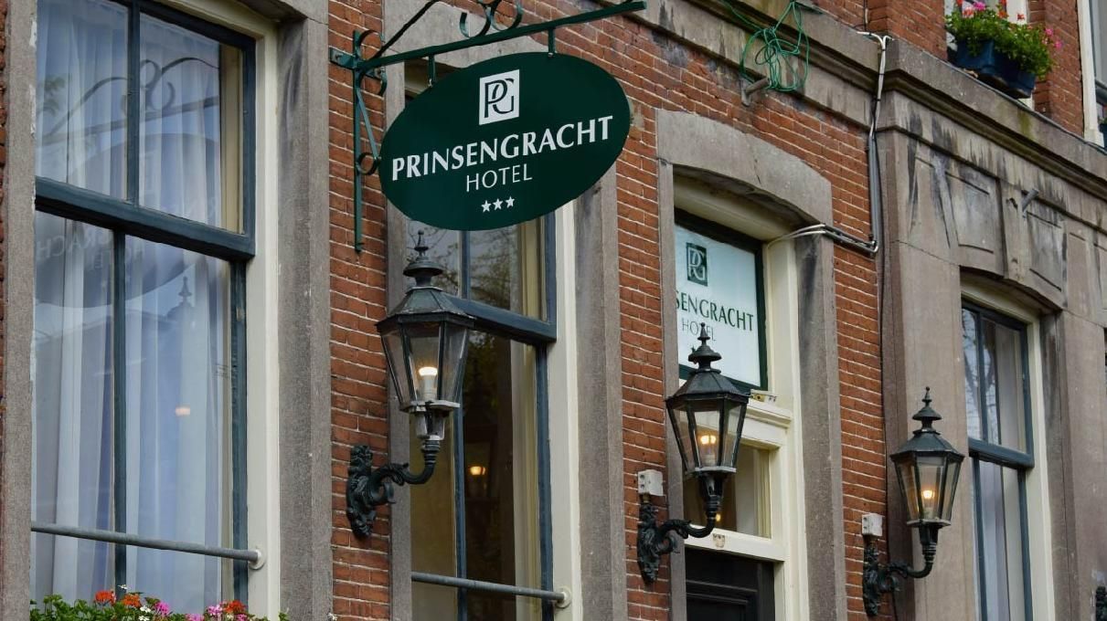 Hotelbord "Prinsengracht Hotel" op een bakstenen gebouw met lantaarns in Amsterdam.