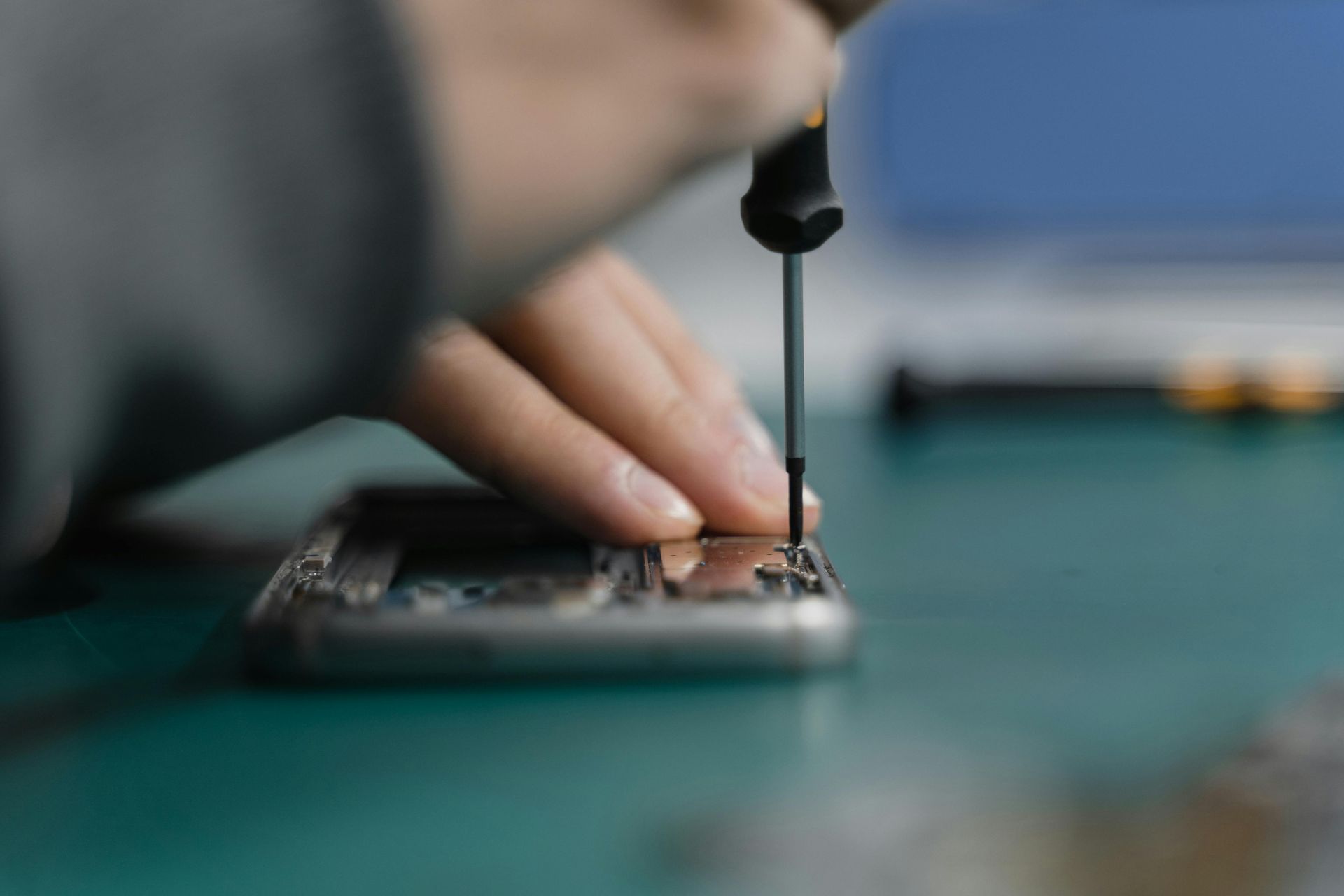 Una persona utiliza un destornillador de precisión para trabajar en los componentes internos de un teléfono inteligente