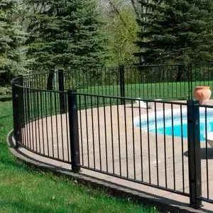 Valla de metal negro alrededor de una piscina, con árboles al fondo.