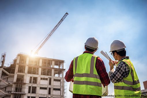 Zwei Bauarbeiter vor einem Hausbau