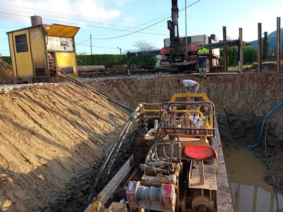 Una excavadora amarilla está cavando un hoyo en el suelo en un sitio de construcción.