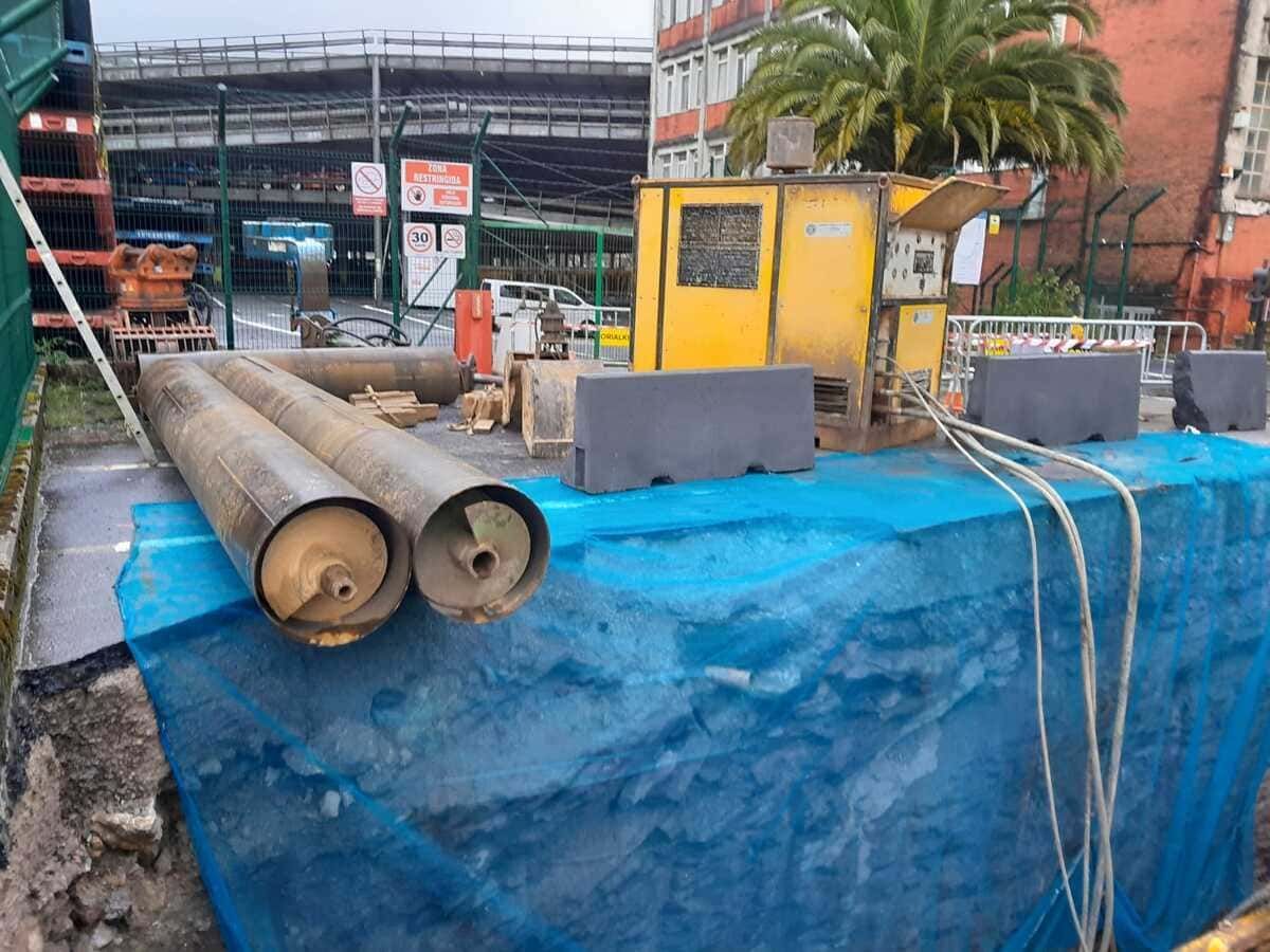 Una excavadora amarilla está cavando un hoyo en el suelo en un sitio de construcción.