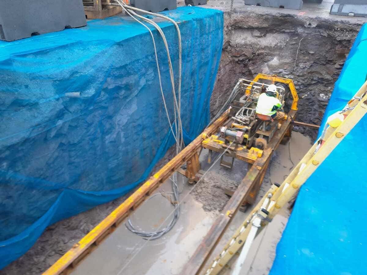 Una excavadora amarilla está cavando un hoyo en la tierra.