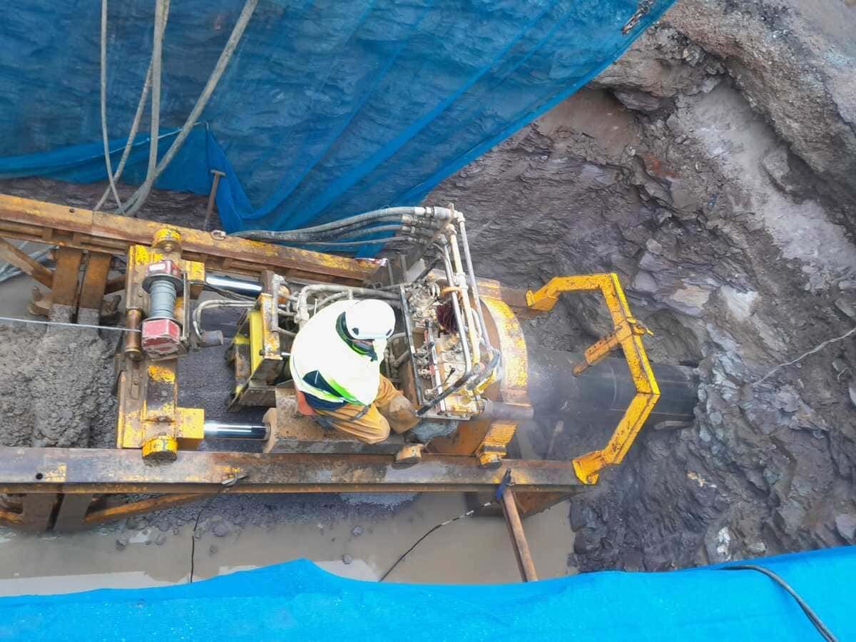 Una excavadora amarilla está cargando tierra en un camión volquete.