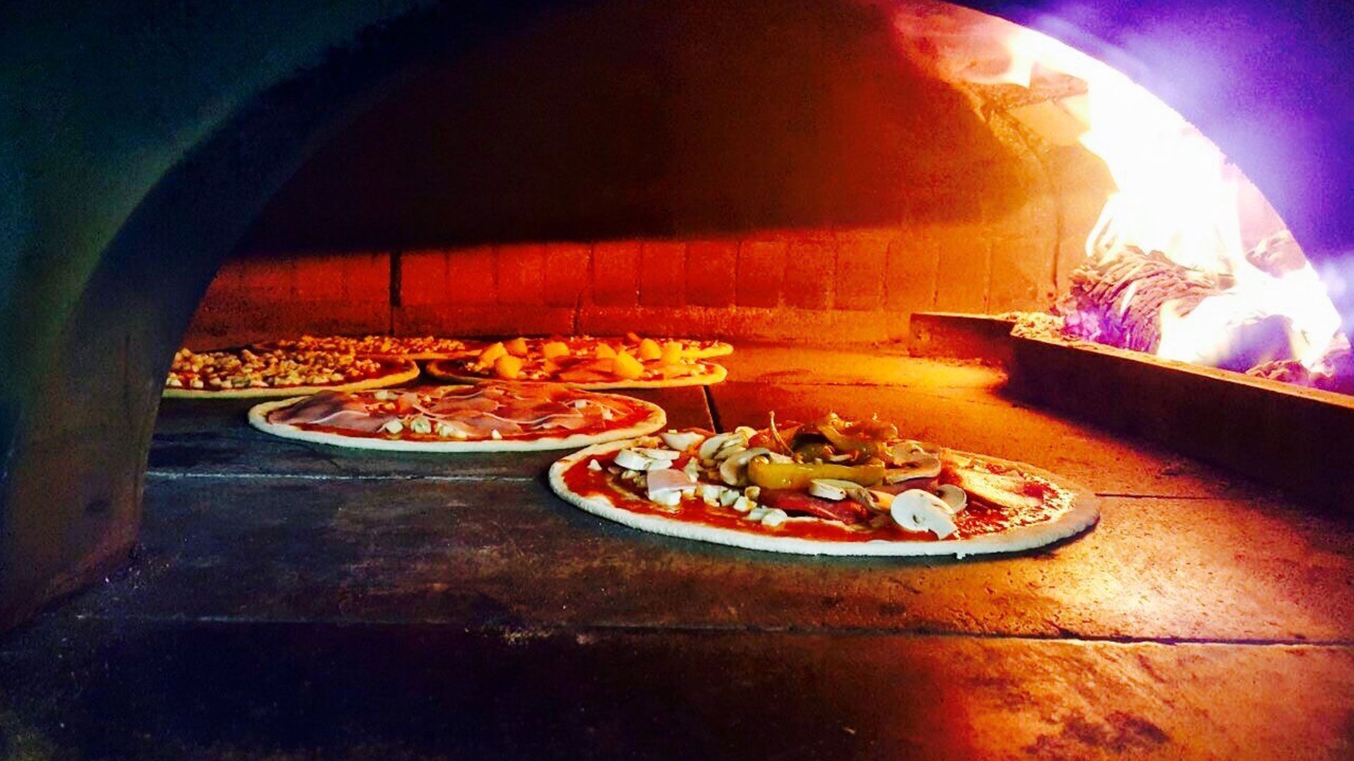 drei Pizzas werden in einem Backofen gebacken