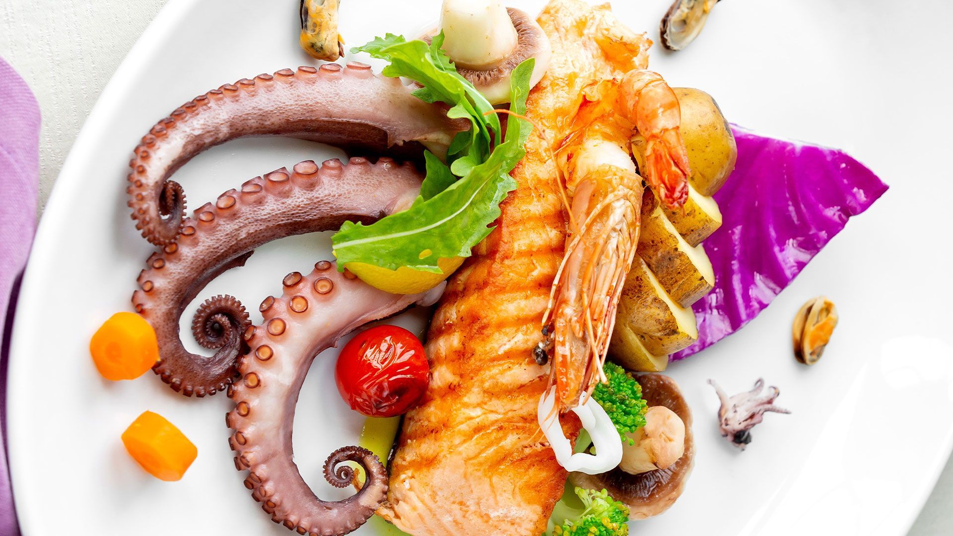 ein weißes Teller mit Fisch und Meeresfrüchten