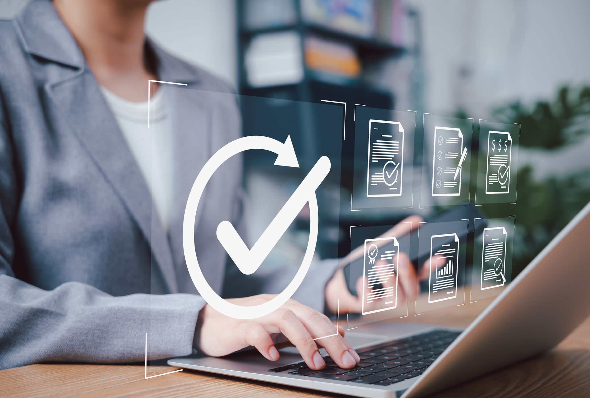 Personne travaillant sur un ordinateur portable, documents numériques, icône de coche, environnement de bureau.