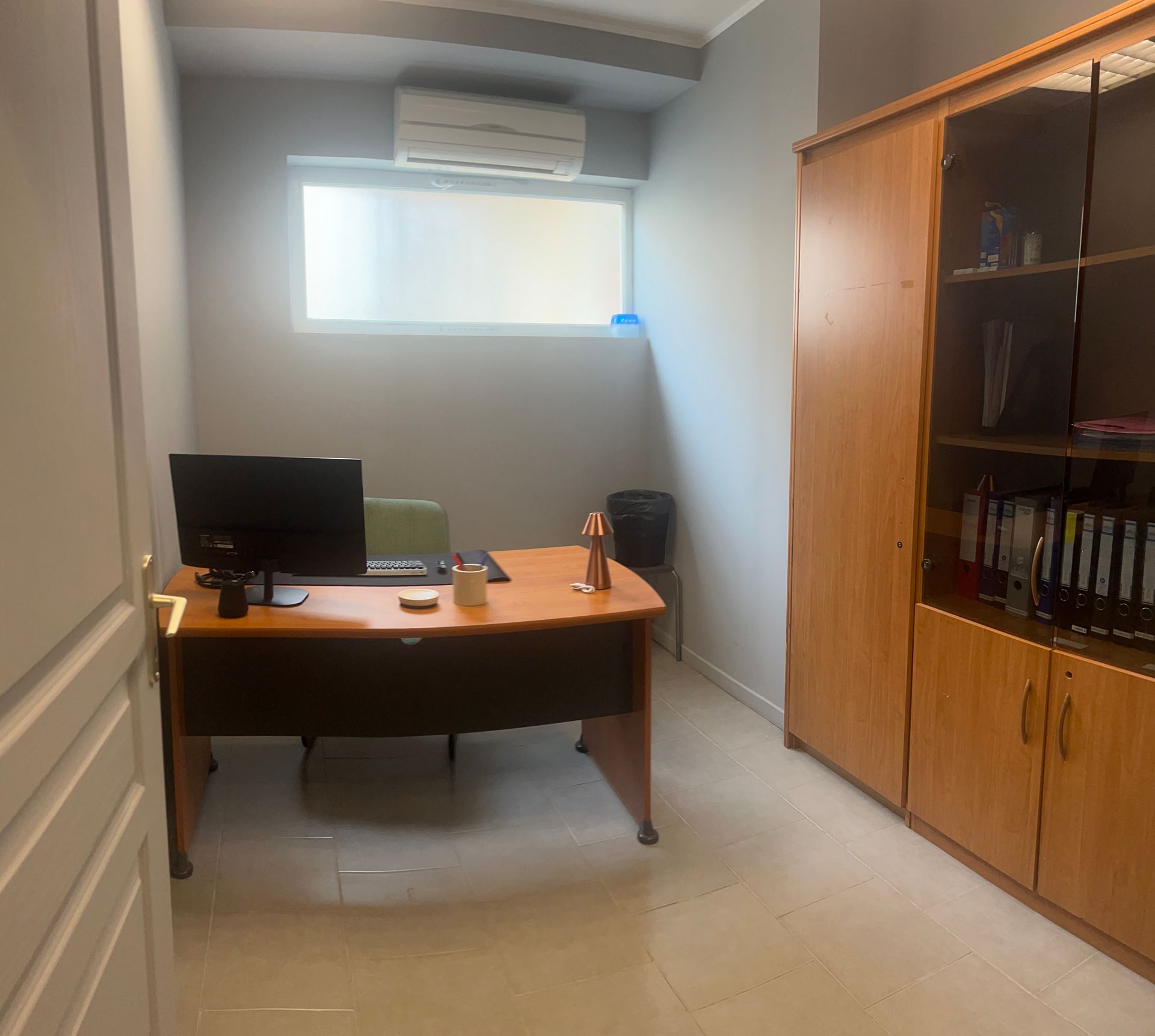 Des personnes travaillant dans un bureau moderne avec des ordinateurs, des murs en briques et de grandes fenêtres.