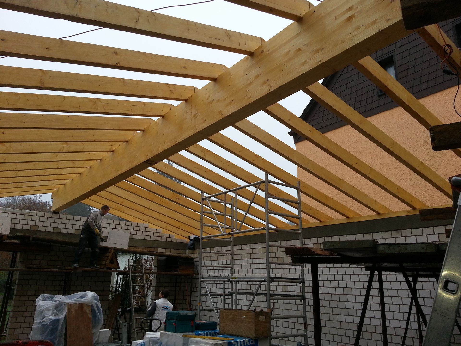 Das Dach eines Gebäudes wird mit Holzbalken gebaut