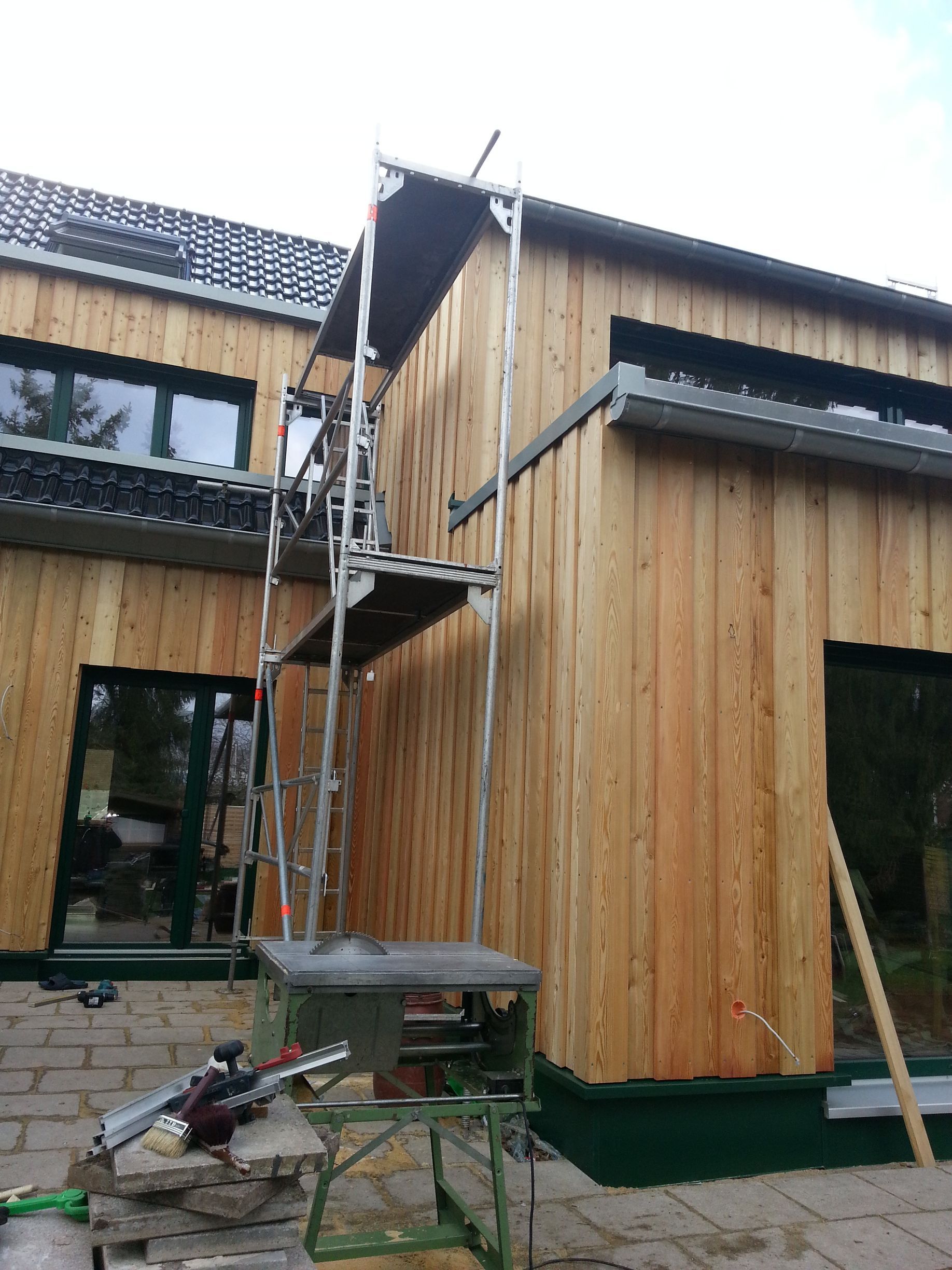 Ein Holzhaus mit einem Gerüst an der Seite.